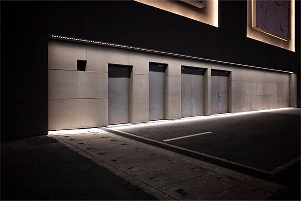 A smooth modern building facade lit evenly with wall washers